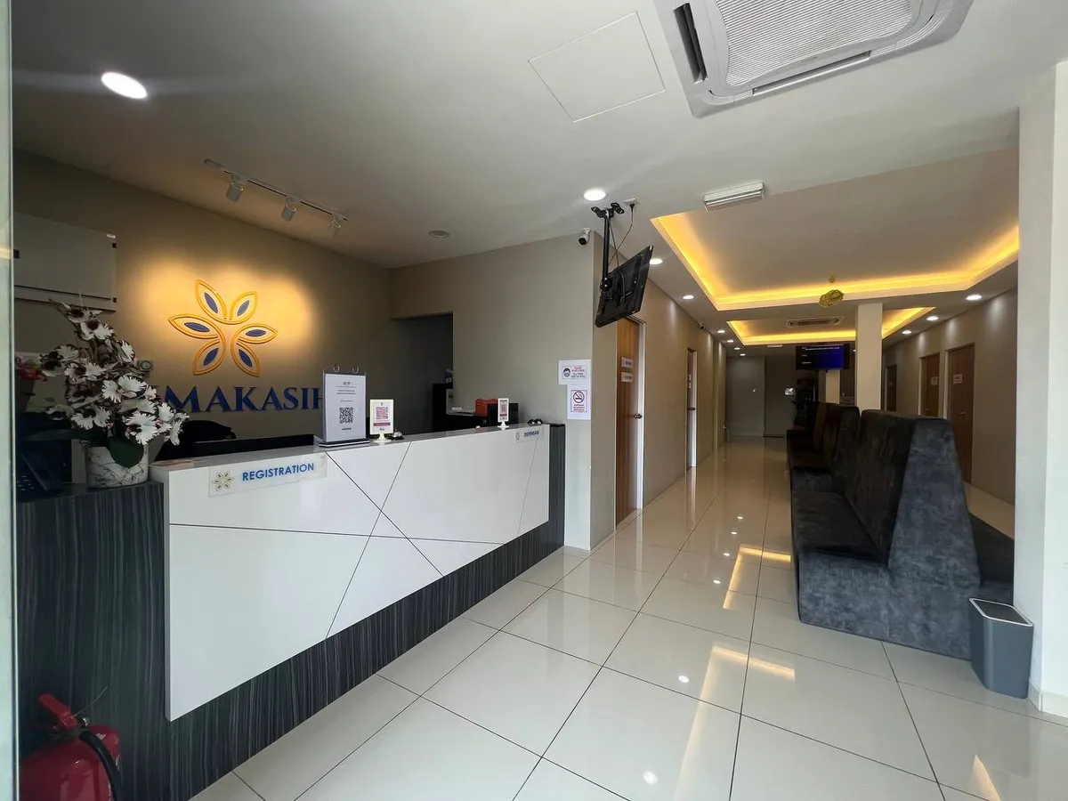 Kaunter pendaftaran Klinik Primakasih dengan logo klinik di belakang kaunter