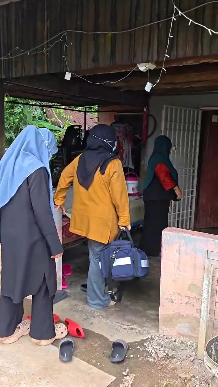 Staf membawa beg peralatan untuk lawatan ke rumah